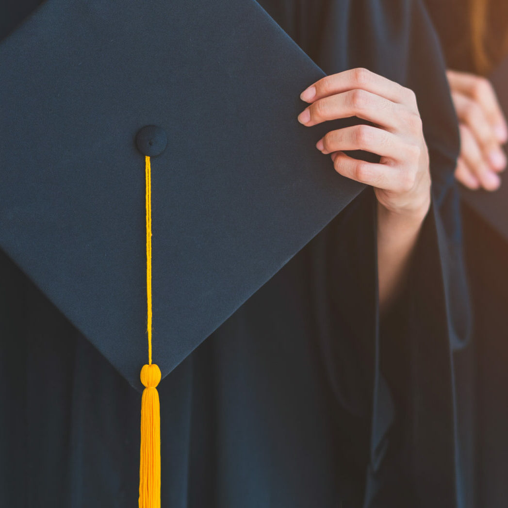 Close up group of graduates holding a hat At the graduation ceremony at the university